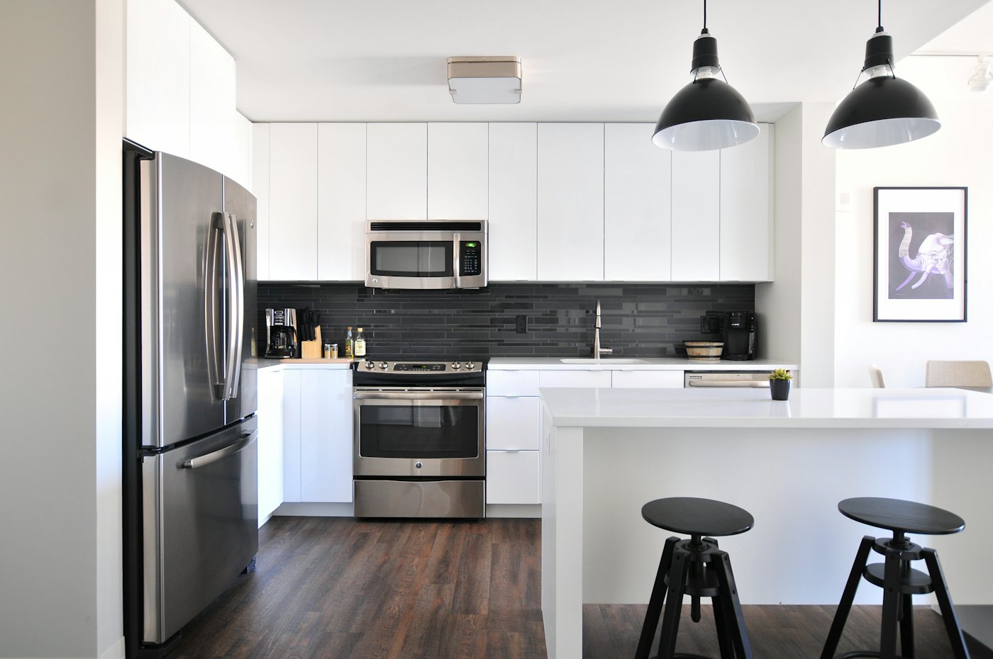 Modern white kitchen with black tile backsplash and island